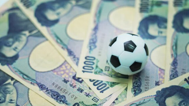 Soccer ball on stack of yen