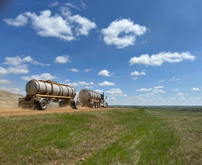 Obraz premium A tanker truck hauls oil along a scoria road in the Bakken in North Dakota