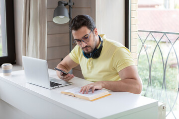 Young handsome man studying online at home. Distance education concept	