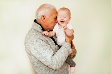 Elderly Man Holding and Kissing a Smiling Baby