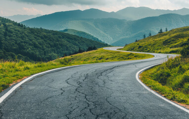 Fototapeta premium Winding road through lush green mountains on a cloudy day, perfect for nature lovers, travel enthusiasts, and adventure seekers looking for scenic routes.