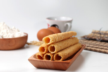 Egg rolls, original flavor. Rolled thin crepes. On wooden plate. Isolated on white background, Bright mood. Perfect for recipe, article, catalogue, or any commercial purposes. With copy space.
