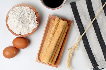 Egg rolls, original flavor. Rolled thin crepes. On wooden plate. Isolated on white background, Bright mood. Perfect for recipe, article, catalogue, or any commercial purposes. With copy space.