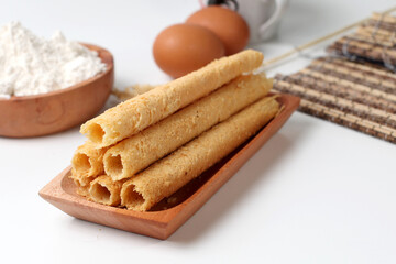 Egg rolls, original flavor. Rolled thin crepes. On wooden plate. Isolated on white background,...
