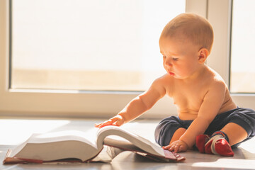 Sweet baby boy reading the book. Copy space for text or design.