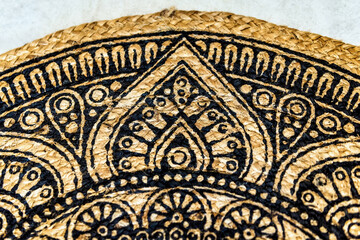 Close-up of a section of a woven summer rug made from jute fibers. The natural texture and pattern of the jute create a rustic and organic feel,highlighting the intricate craftsmanship and earthy tone