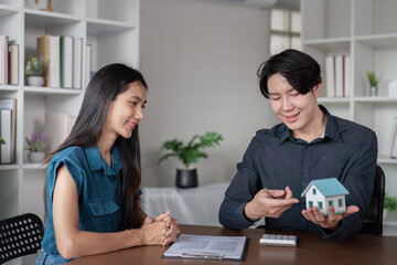 Fototapeta premium Real Estate Agent Showing Model House to Client in Modern Office Setting