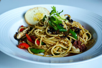 A plate of spaghetti with garlic, olive oil, and vegetables.