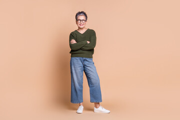 Photo of charming nice mature woman wear green stylish outfit crossed arms isolated on beige color...