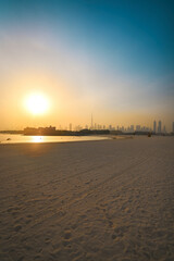 View of sunrise over a beach in Dubai overlooking Dubai skyline