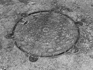 Manhole grunge style background, ground close view photo. Black and white monochrome photo. Pencil drawn sketch