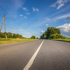 Fototapeta premium A road with a white line down the middle and trees in the background