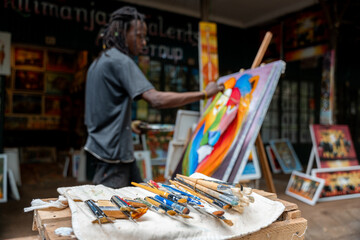 African american artist painting with acrylic paint in studio