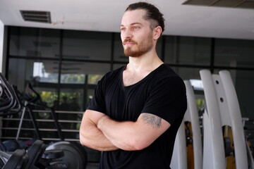 Young man standing and smiling in the fitness center Exercise for health.