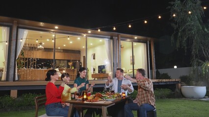 Happy family holding glowed sparkler in holiday celebration party at night. Lovely member enjoy playing spark toy together. Outdoor activity to cross generation gap strengthen family bond. Divergence.