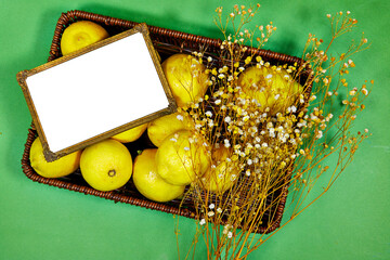 halfah basket full of lemons with gypsophila flowers and frame photo 