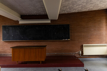 Compulsory school. University, academy, high school. Back to school. Old class, vintage love. Classroom with desk and ancient dirty blackboard, chalk, eraser. Lesson, questions, anxiety about exams. 