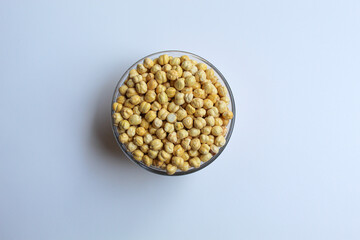 Chickpeas in glass transparent bowl, isolated on white background, flat lay or top view