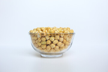 Chickpeas in glass transparent bowl, isolated on white background