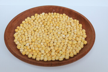 Chickpeas in wooden plate, isolated on white background