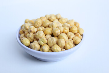 Chickpeas in small white bowl, isolated on white background