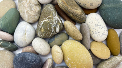 Sea stones on a white background. Lots of sea pebbles