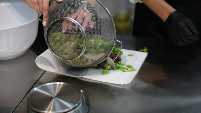 Drying washed lettuce leaves on a paper towel. blot the lettuce leaves with a paper towel