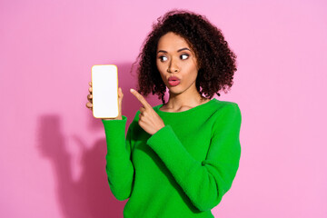 Photo portrait of lovely young lady show point amazed white screen dressed stylish green garment isolated on pink color background