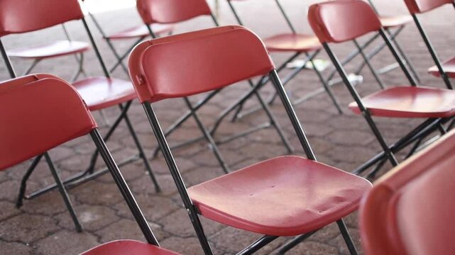 Sillas color rojo apiladas y vac&iacute;as de algun evento 