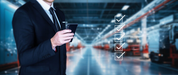 Business performance approved concept, businessman using smartphone or digital device to industrial safety checklist, manufacturing audit, quality product, quality assurance.