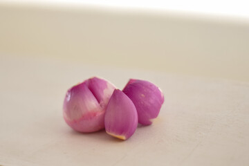 Peeled red onion isolated. A bunch of red onions. Red onion isolated on light cream background