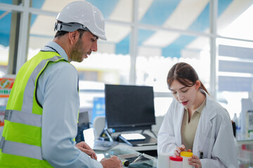 A female pharmacist is talking with a construction worker who needs medicine for pain and discomfort. Pharmacist in a pharmacy with medicines on shelves