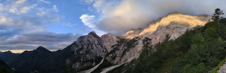 Panoramic view of the Slovenian Alps from a hiking trip and via ferrata to the top of Grintovec mountain on a hot summer day. Stunning alpine landscapes and challenging trails.

