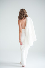 Elegant woman in white suit on white background