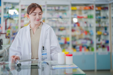 A pharmacist prepares medicine on the counter of a pharmacy. At the back there is a shelf that stores drug samples and chemical products.