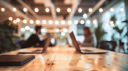 Coffee break in a modern office. A cup of coffee sits on a wooden table in a modern office. The blurred background features people working on laptops, creating a relaxed and productive atmosphere.
