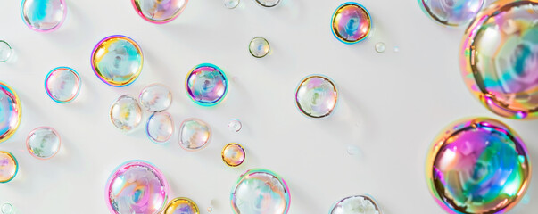 Multiple bubbles with rainbow-like iridescence scattered across a blank white backdrop, showcasing their delicate beauty.