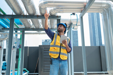 Engineer Inspecting Industrial Pipes on Rooftop