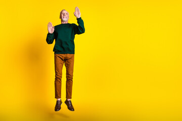 Full size photo of nice senior man jump touch wall mime dressed stylish green clothes isolated on...