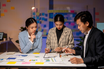 Three people are sitting at a table, looking at a presentation