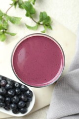 Tasty fresh acai juice in glass on light table, top view