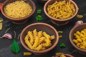 Pasta. Various kinds of uncooked pasta and noodles over wooden background. Traditional Italian