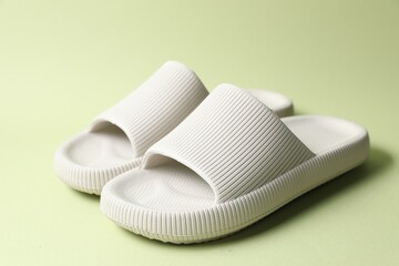 Pair of rubber slippers on green background