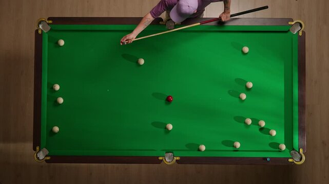 Top view full shot of russian billiard table with white balls scattered around, person polishing the billiard cue with chalk.