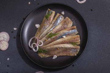 Fillet of pickled marinated sea herring fish with shallots and dill. Served ready to eat seafood