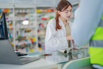 A pharmacist prepares medicine on the counter of a pharmacy. At the back there is a shelf that stores drug samples and chemical products.