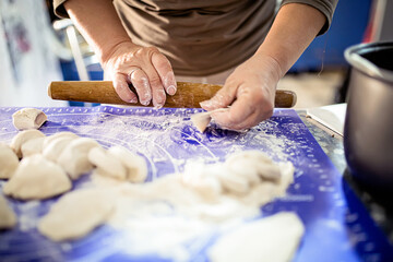 Close Up of Hands Shaping Dough for Dumplings in a Kitchen
