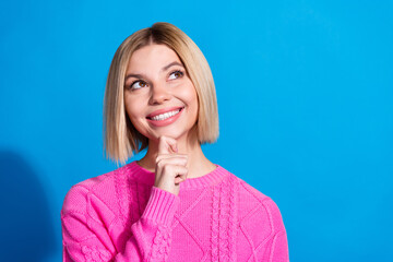 Portrait of nice young woman look empty space wear pink sweater isolated on blue color background