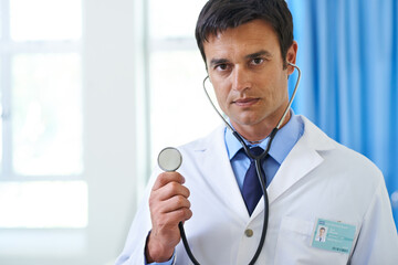 Cardiologist, man and portrait with doctor in office, stethoscope and medical instrument in check up. Heart rate, monitor and wellness service in clinic employee, professional and health consultation