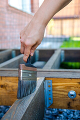 Molar brush in the hand master. Treatment of wooden boards with protective soil, oil for wood.